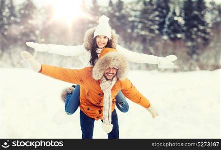 people, season, love and leisure concept - happy couple having fun over winter background. happy couple having fun over winter background