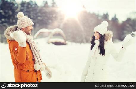 people, season, love and leisure concept - happy couple playing snowballs in winter. happy couple playing snowballs in winter