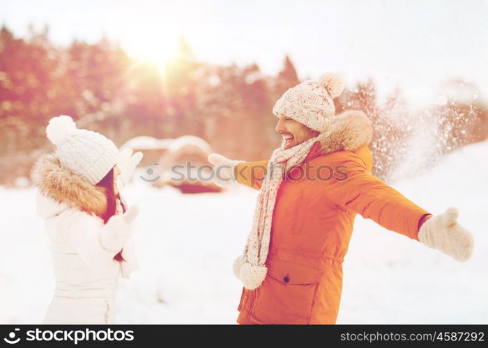 people, season, love and leisure concept - happy couple playing with snow in winter