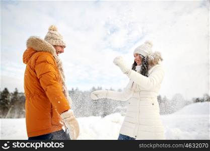 people, season, love and leisure concept - happy couple playing with snow in winter