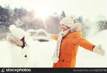 people, season, love and leisure concept - happy couple playing with snow in winter. happy couple playing with snow in winter