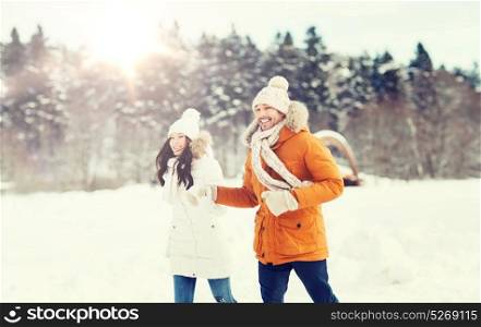 people, season, love and leisure concept - happy couple running over winter background. happy couple running over winter background