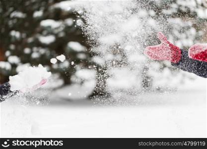 people, season, winter holidays and christmas concept - happy friends playing with snow outdoors