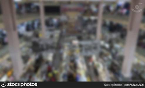 people selling and buying food and cloth at stall in local grocery market - blur for use as background