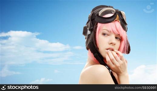 people, sexuality and role-playing games concept - pink hair girl in aviator helmet over blue sky and clouds background