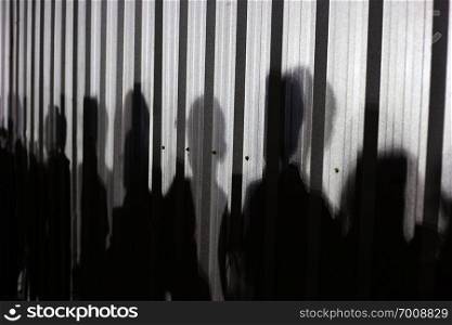 People shadow on zinc wall background.