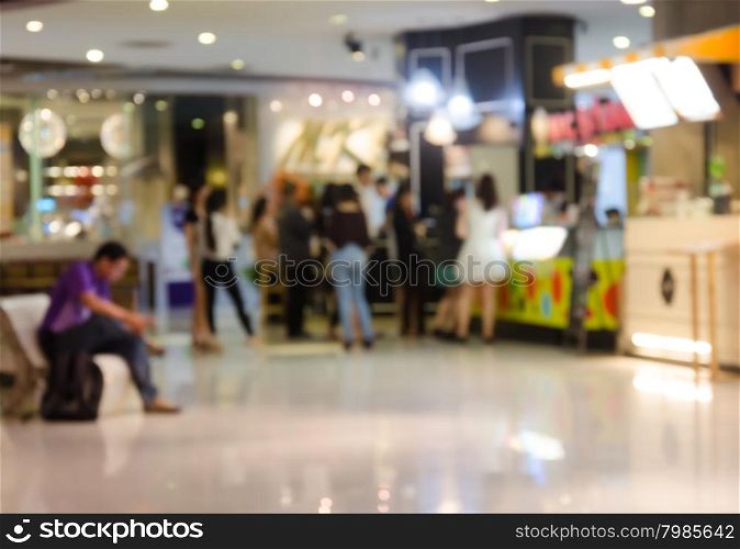 People shopping in department store. Defocused blur background.