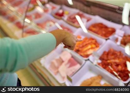 people, shopping, sale and food concept - customer hand pointing at meat on grocery stall