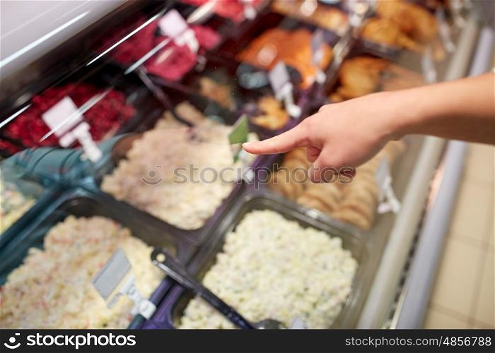 people, shopping, sale and food concept - customer hand pointing at salads on grocery stall