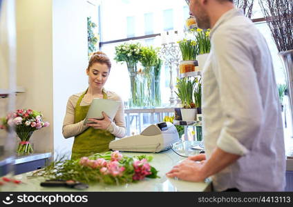 people, shopping, sale, floristry and consumerism concept - happy smiling florist woman with tablet pc computer and man or customer at flower shop