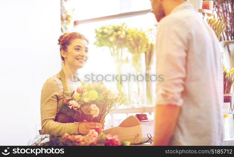 people, shopping, sale, floristry and consumerism concept - happy smiling florist woman making bouquet for and man or customer at flower shop. smiling florist woman and man at flower shop