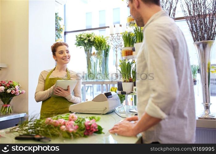 people, shopping, sale, floristry and consumerism concept - happy smiling florist woman with tablet pc computer and man or customer at flower shop