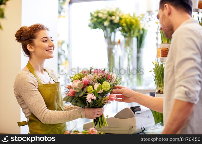 people, shopping, sale, floristry and consumerism concept - happy smiling florist woman making bouquet for and man or customer at flower shop