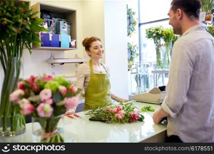 people, shopping, sale, floristry and consumerism concept - happy smiling florist woman and man or customer talking at flower shop