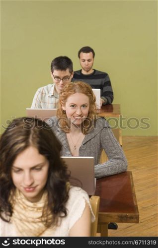 People sitting at desks with laptops