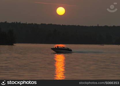 People sitting on boat moving in the lake, Lake of The Woods, Ontario, Canada