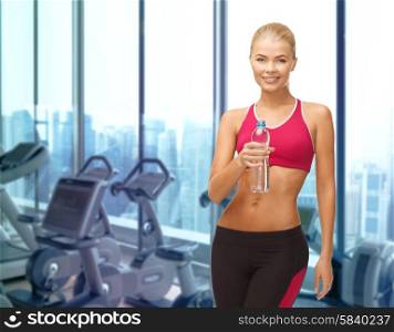 people, sport, fitness and recreation concept - happy woman with bottle of water over gym machines background