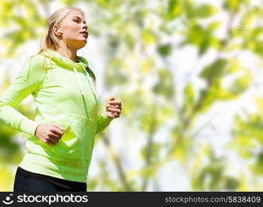 people, sport, fitness and slimming concept - happy woman running or jogging over green leaves background