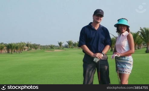 People, sport, leisure activity, recreation and lifestyle, golf in country club during summer holidays. Portrait of players in golf course, looking at camera. Multi-ethnic couple, man and woman. 6of30