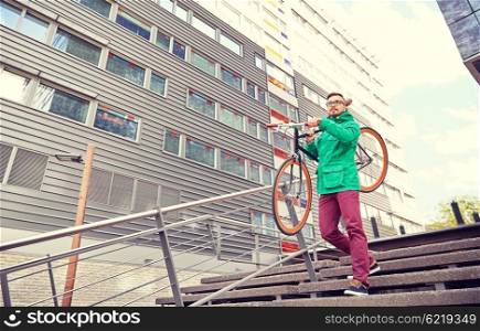 people, sport, style, leisure and lifestyle - young hipster man carrying fixed gear bike on shoulder down stairs in city