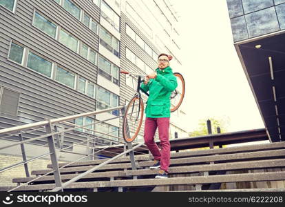 people, sport, style, leisure and lifestyle - young hipster man carrying fixed gear bike on shoulder down stairs in city