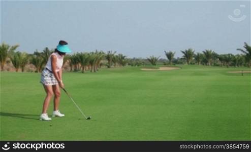 People, sports, leisure activities, recreation and lifestyle, golf in country club during summer holiday. Asian woman hitting ball with iron in golf course. 11of30