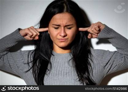 people, stress and domestic violence concept - unhappy woman closing ears by fingers. unhappy woman closing ears by fingers