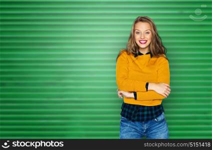 people, style and fashion concept - happy young woman or teen girl in casual clothes over green ribbed wall background. happy young woman or teen girl in casual clothes