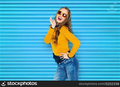 people, style and fashion concept - happy young woman or teen girl in casual clothes and sunglasses having fun over blue ribbed background. happy young woman or teen girl in casual clothes
