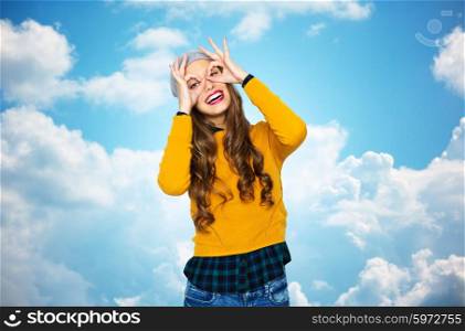 people, style and fashion concept - happy young woman or teen girl in casual clothes and hipster hat having fun over blue sky and clouds background
