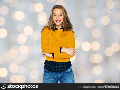 people, style and fashion concept - happy young woman or teen girl in casual clothes over holidays lights background