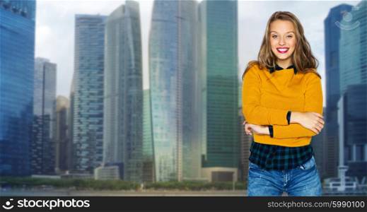 people, style and fashion concept - happy young woman or teen girl in casual clothes over city buildings and skyscrapers background