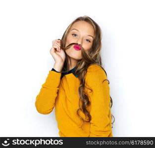 people, style and fashion concept - happy young woman or teen girl in casual clothes having fun making mustache of her hair strand