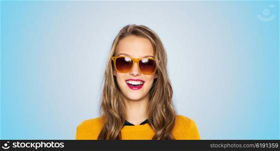 people, style and fashion concept - happy young woman or teen girl face in sunglasses over blue background