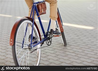 people, style and lifestyle - close up of hipster man riding fixed gear bike on city street