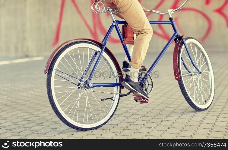 people, style and lifestyle - close up of hipster man riding fixed gear bike on city street. close up of hipster man riding fixed gear bike