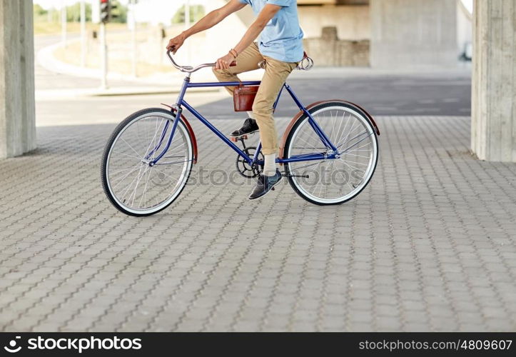 people, style and lifestyle - hipster man riding fixed gear bike on city street