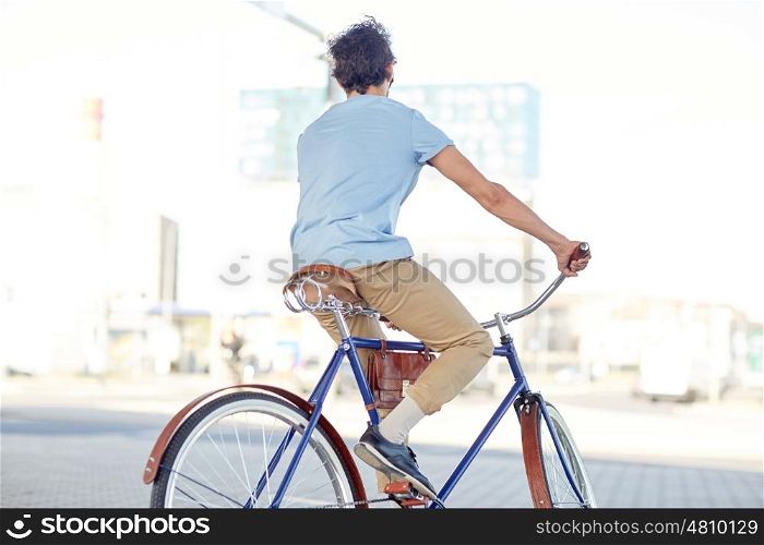 people, style and lifestyle - hipster man riding fixed gear bike on city street