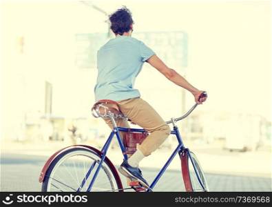 people, style and lifestyle - hipster man riding fixed gear bike on city street. hipster man riding fixed gear bike