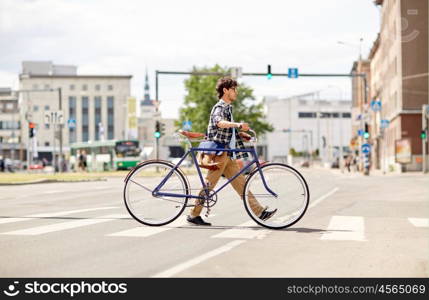 people, style, city life and lifestyle - young hipster man with shoulder bag and fixed gear bike crossing crosswalk on street