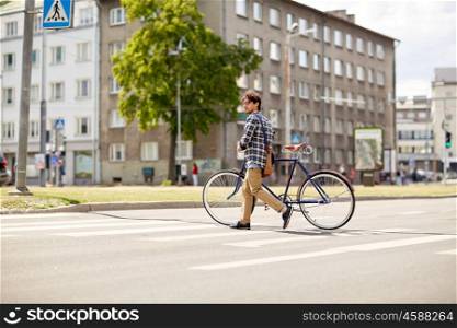 people, style, city life and lifestyle - young hipster man with shoulder bag and fixed gear bike crossing crosswalk on street