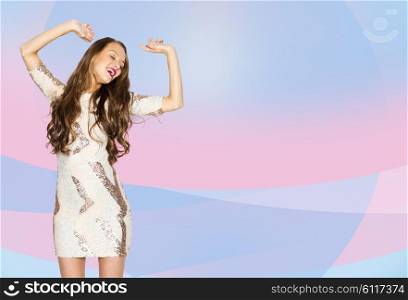 people, style, holidays and fashion concept - happy young woman or teen girl in fancy dress with sequins and long wavy hair dancing at party over pink violet background