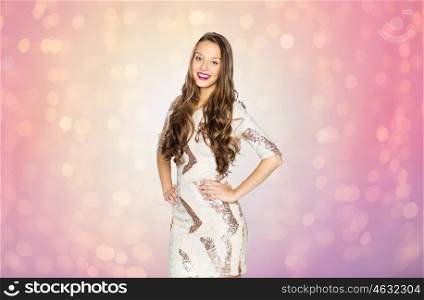 people, style, holidays, hairstyle and fashion concept - happy young woman or teen girl in fancy dress with sequins and long wavy hair over rose quartz and serenity lights background