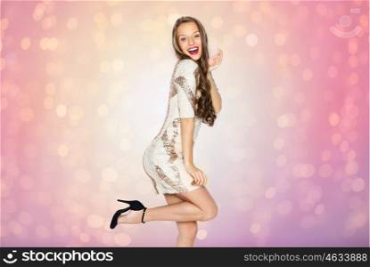 people, style, holidays, hairstyle and fashion concept - happy young woman or teen girl in fancy dress with sequins and long wavy hair posing over rose quartz and serenity lights background