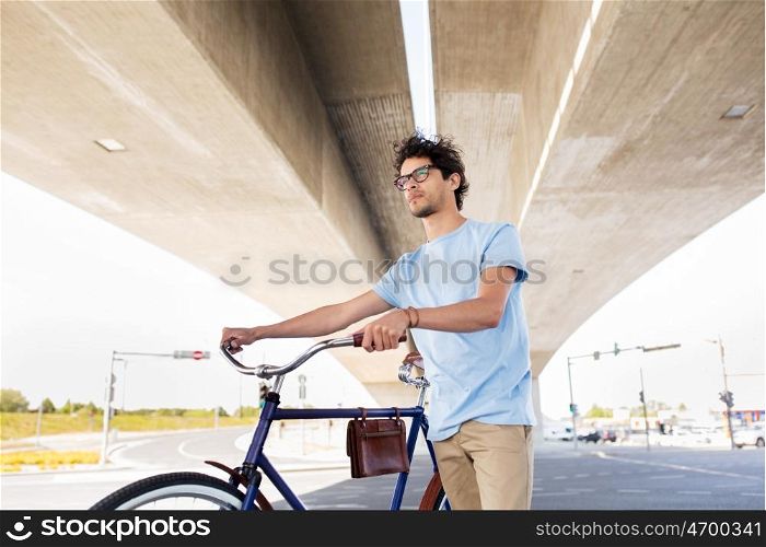 people, style, leisure and lifestyle - hipster man with fixed gear bike under city bridge
