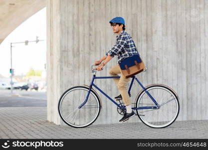 people, style, leisure and lifestyle - young hipster man with shoulder bag riding fixed gear bike on city street