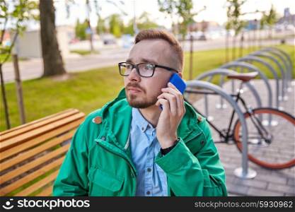 people, style, technology and lifestyle - young hipster man with smartphone and fixie byke sitting on bench in city