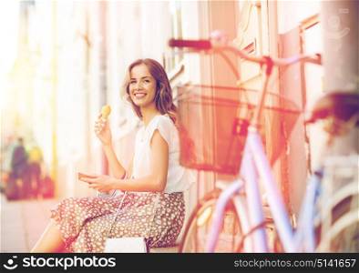 people, style, technology, leisure and lifestyle - happy young hipster woman with smartphone and fixed gear bike eating ice cream on city street. happy woman with smartphone, bike and ice cream