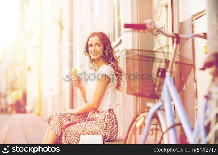 people, style, technology, leisure and lifestyle - happy young hipster woman with fixed gear bike eating ice cream on city street. happy woman with bike and ice cream