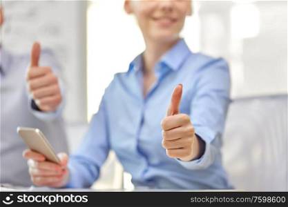 people, success and gesture concept - portrait of happy smiling young woman showing thumbs up. portrait of smiling young woman showing thumbs up